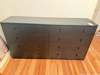 Full front and top view of black 8-drawer dresser