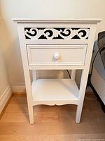 Front view showing scroll cutout, drawer and shelf