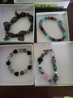 Four assorted bracelets showing variety of bead shapes, colours and one with toggle clasp
