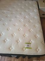 Top view of white quilted mattress on bed frame