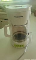 Front view of the Black & Decker white drip coffee maker with carafe and power cord