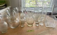 All 14 clear glass vases on tabletop