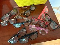 Multiple pairs of reading glasses laid out showing styles and colors