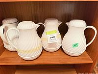 Four white insulated servers on shelf