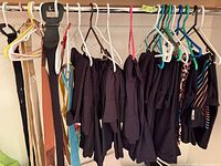 Belts and pants hanging on closet rod