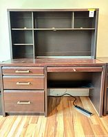 Front view of desk and hutch showing drawers, shelves, keyboard tray, cable hole