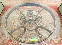 Overhead view showing full round glass top and ornate metal base layout