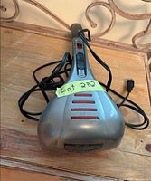 Top view of grey HoMedics percussion massager showing handle, vents, and cord