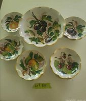 Top view of complete set: 1 large bowl, 5 small bowls, fruit motifs visible