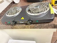Front angled view showing two coil burners, control knobs and indicator lights