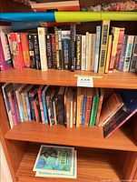 Two shelves filled with assorted hardcover and paperback books