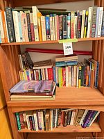 Full view of three bookcase shelves filled with assorted books
