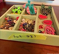 Tray segmented with various colourful earrings visible