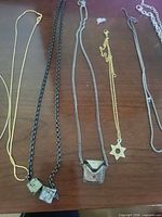 Overall view of multiple necklaces laid out showing chains and pendants
