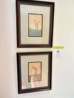 Both framed golf prints hanging on wall