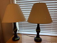 Both table lamps with shades on tabletop, blinds behind