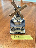 Front view of Delft Blue porcelain windmill showing floral decoration and metal blades