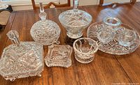 Group shot of all nine clear cut crystal pieces on table