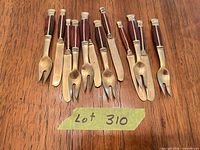 Full set of 11 brass and rosewood flatware pieces laid out