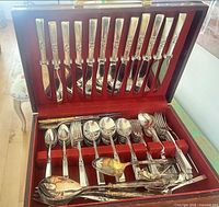 Open case displaying full flatware set in burgundy insert
