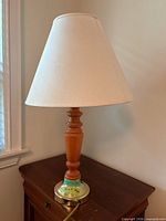 Full view of lamp showing wood column, brass base, fabric shade