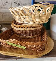 Stack of woven baskets and trays showing variety of shapes and materials