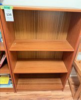 Front view showing three shelves and wood-grain back panel