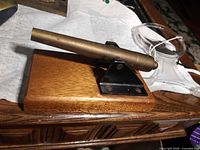 Mini brass cannon on wood base with black steel mount