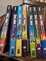 Spines of seven Dog Man hardcover books in order