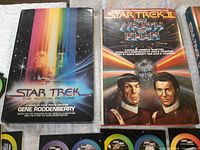 Two hardcover novelizations: Star Trek The Motion Picture and Star Trek II The Wrath of Khan with some discs visible
