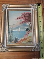 Front view of framed painting with measuring tape