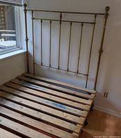 Brass headboard assembled with wooden slat base