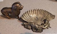 Brass trinket dish and cast iron lion bank, overall view