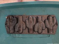 Top view showing five cactus-shaped cavities in cast iron pan