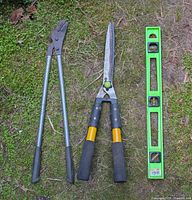 Hedge shears, lopping shears, green plastic level laid out on ground