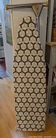 Ironing board folded showing geometric cover and top hinge