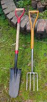 Both tools full length leaning against stone edge
