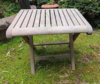 Front view of teak folding table on grass
