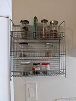 Front view of silver metal wire three-tier spice rack mounted on wall