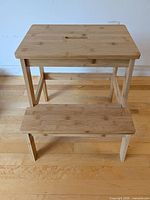 Front view of bamboo two-step stool showing both steps and carry handle