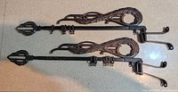 Both telescoping sash curtain rods showing decorative finials and mounting brackets attached