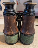 Front view of brass and leather field glasses showing verdigris