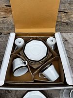 Box with four cups and stack of octagonal plates
