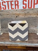 Front view of wool cube ottoman on wood surface