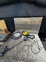 Full view of yellow canister vacuum with hose, wand and floor nozzle