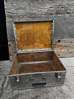 Open aluminum chest showing interior wood lining