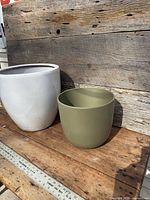 White and green ceramic planters side by side