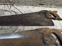 Two hand saws laying flat showing full blades and handles