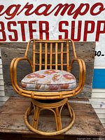 Frontal view of rattan swivel rocker chair showing overall design and cushion