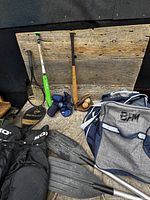 Group view of bats, racquet, gloves, pants, paddles and equipment bag